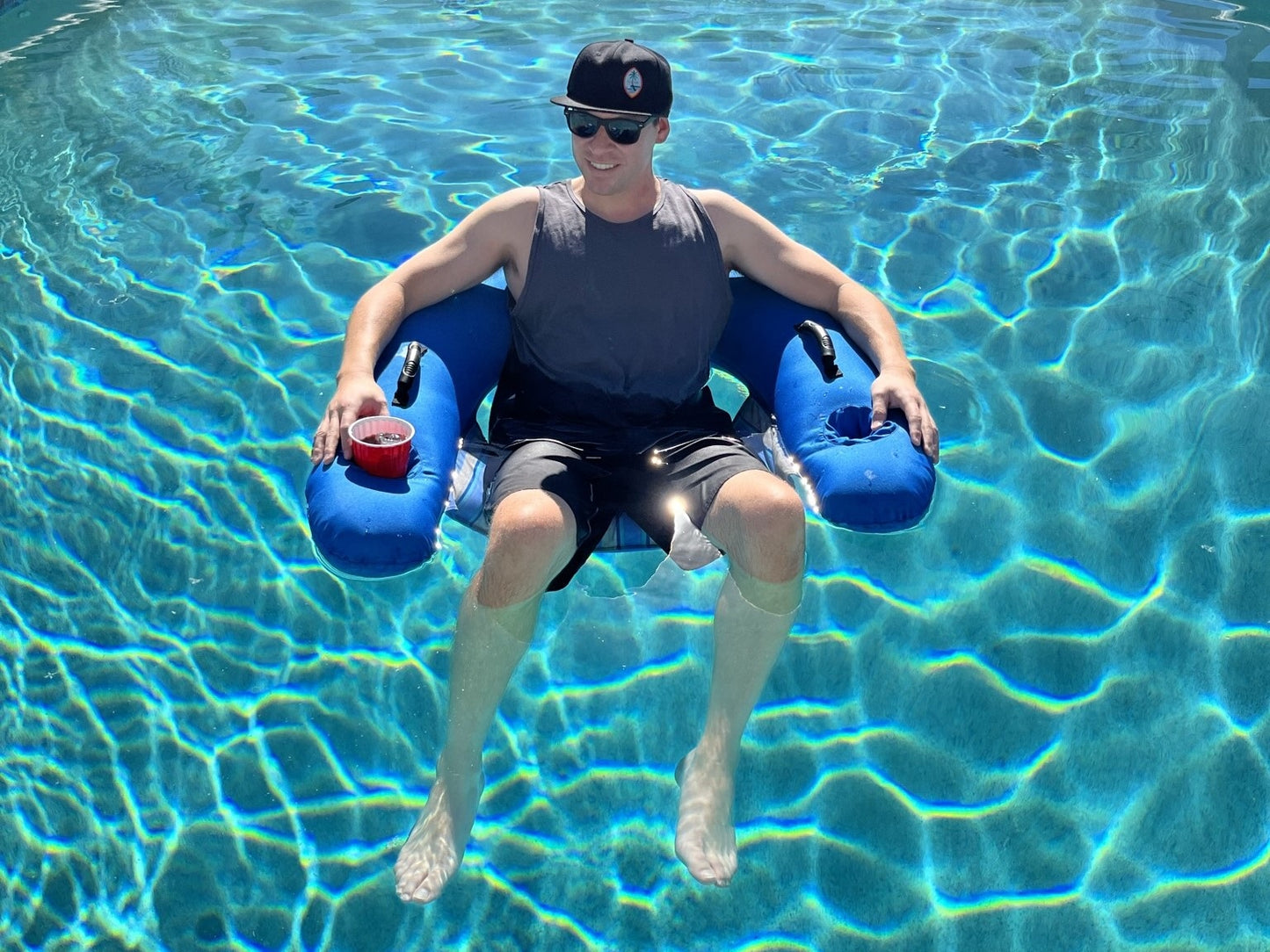 Smiling man floating in pool on Aquaboy Pool Chair.