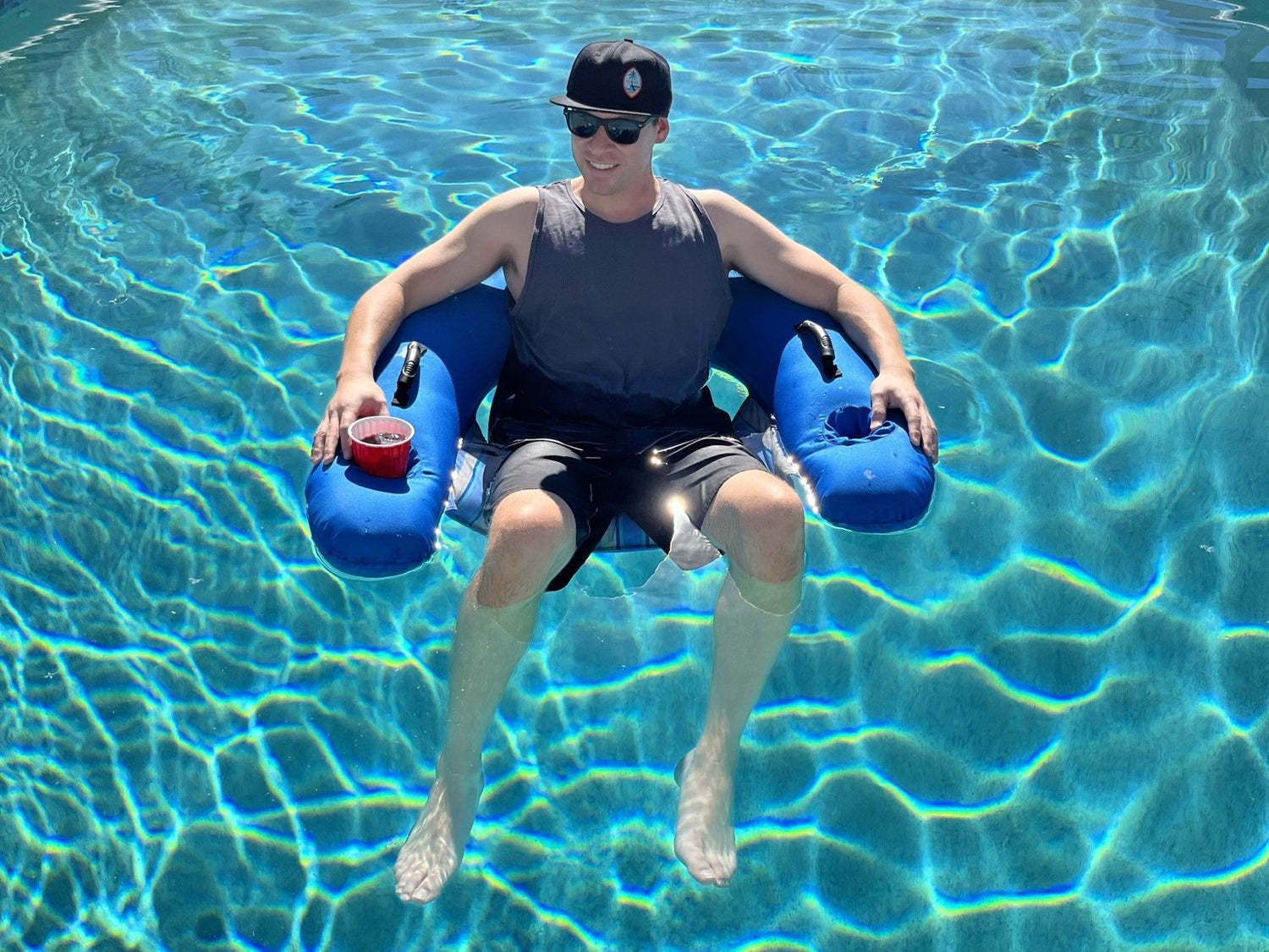 Smiling man floating in pool on Aquaboy Pool Chair.